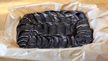 Form mit Backpapier und Teig